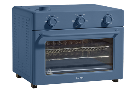 A blue countertop toaster oven with three control knobs on top, a glass door, wire racks inside, and sturdy black feet.
